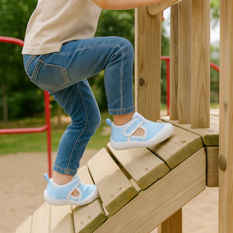 Child wearing light blue shoes on a playground structure