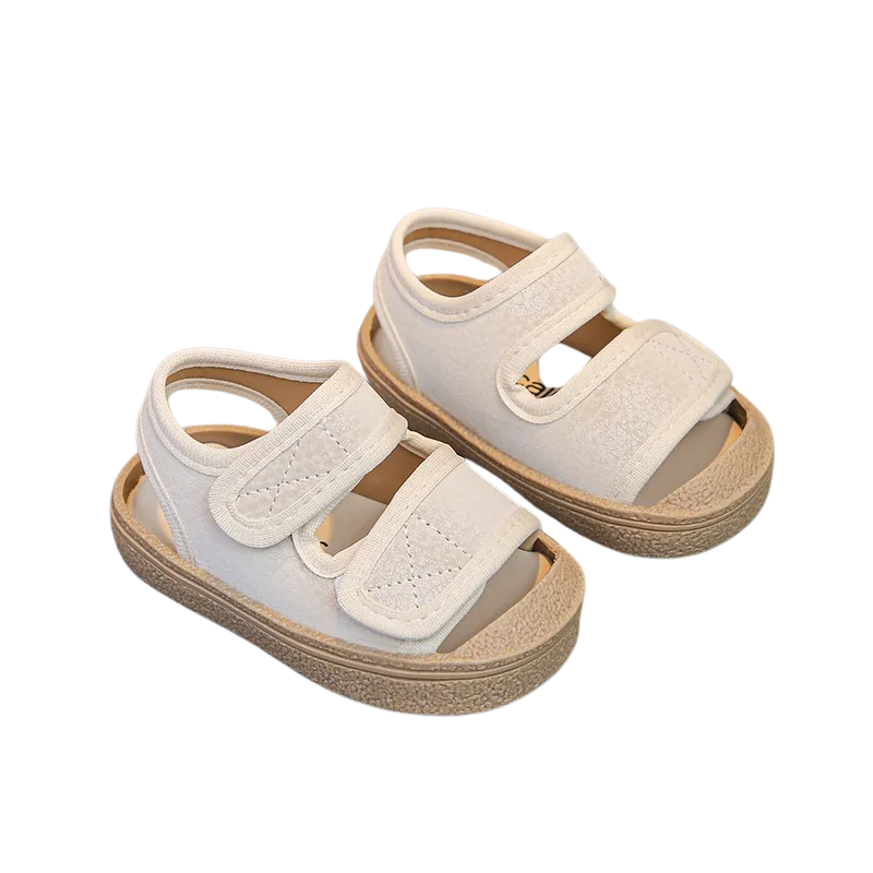 Pair of white sandals with brown soles on a white background