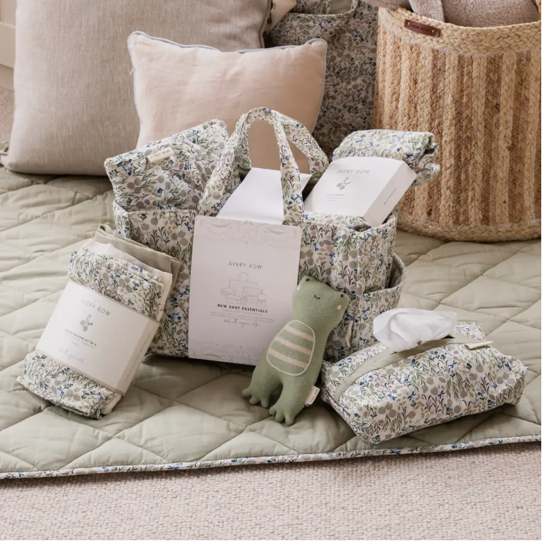 Baby gift set with floral-patterned items on a quilted surface