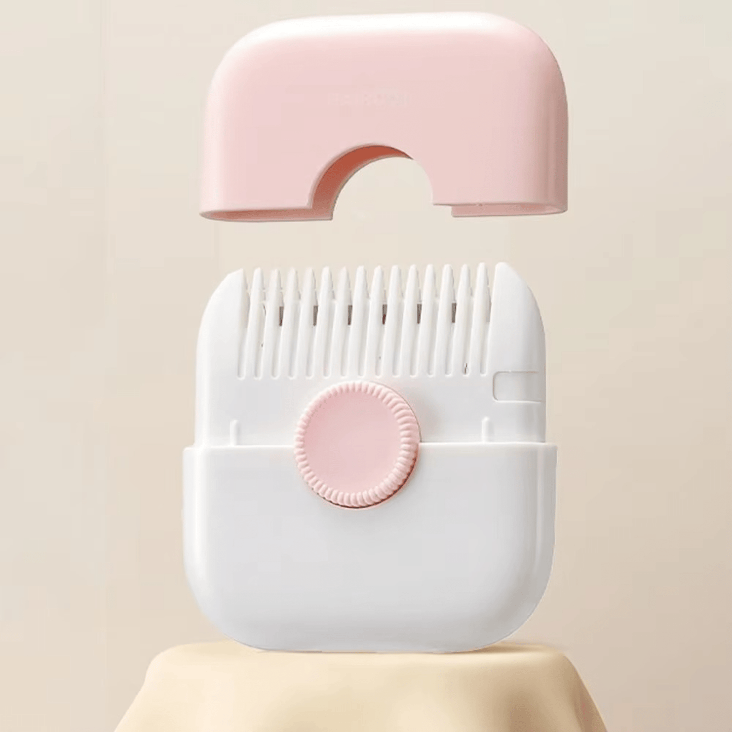 White and pink hair clipper device on a beige background