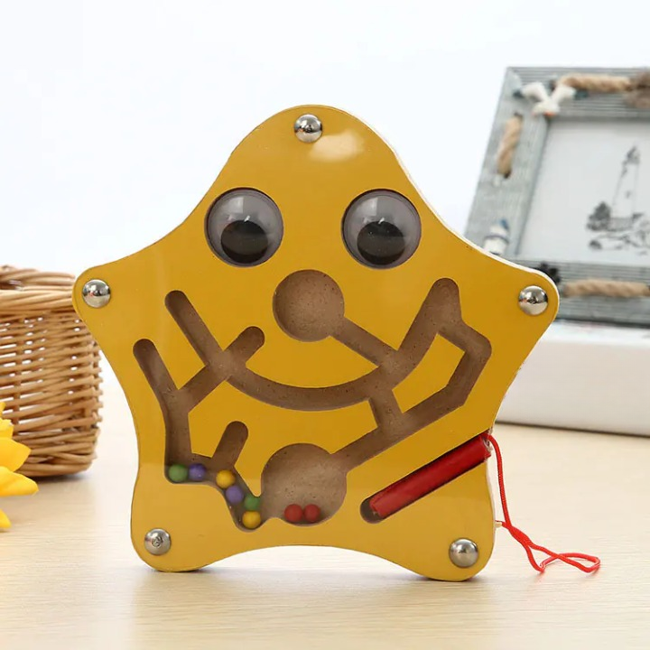 Star shaped maze toy on a light surface with a blurred background