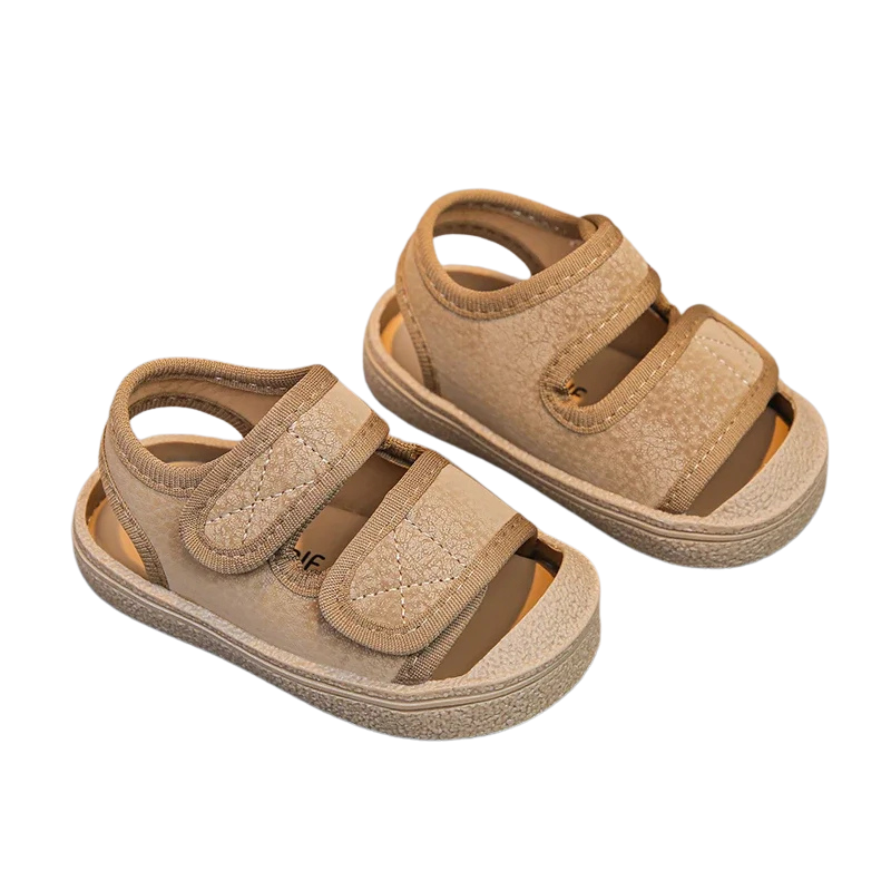 Pair of beige sandals with velcro straps on a white background