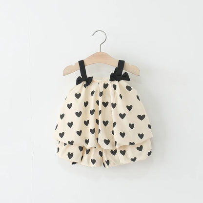 Children's dress with black heart patterns on a white background