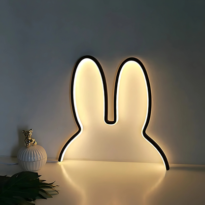 SnuggleBright Bunny-shaped LED night light on a white surface with a dark background