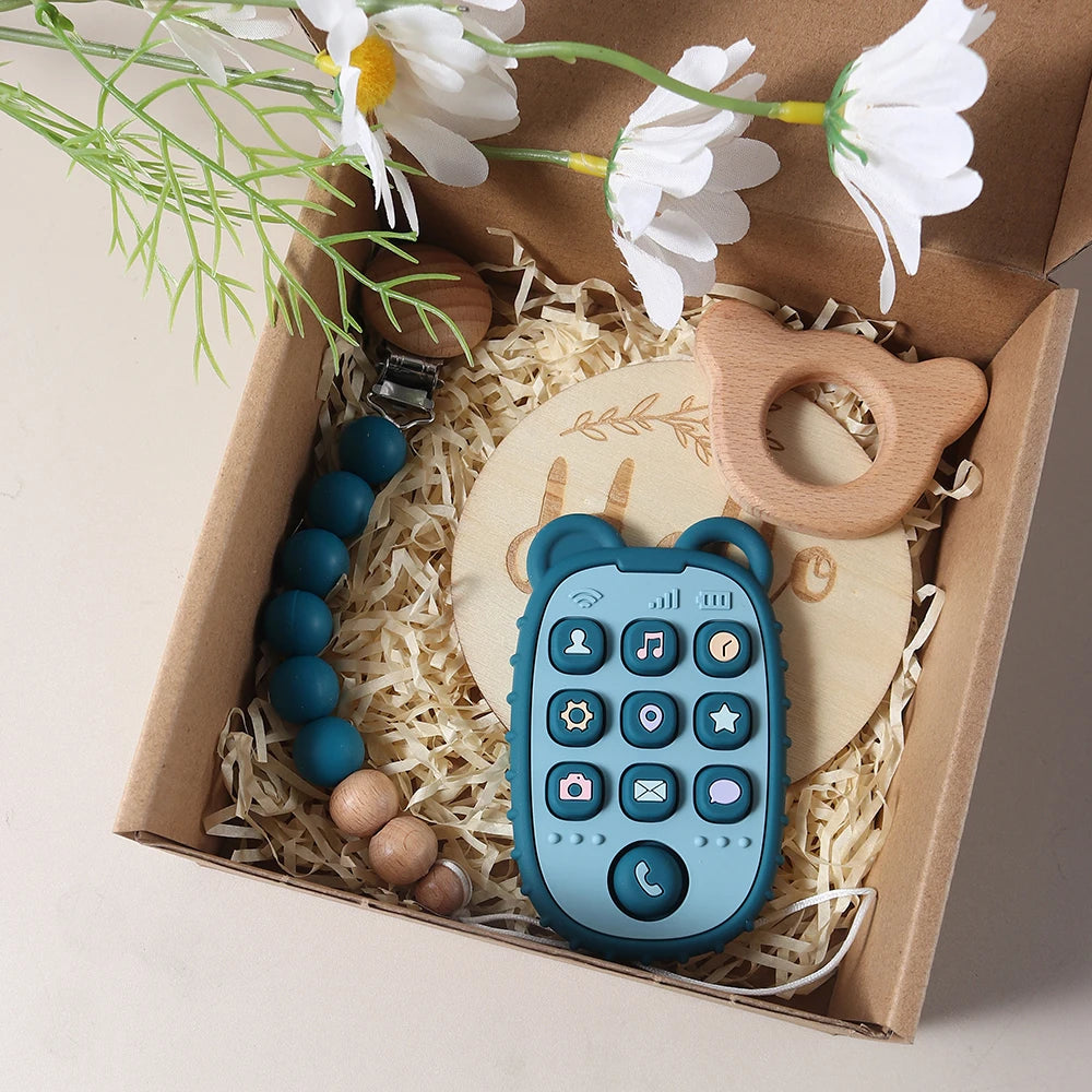 Wooden baby teether, and Blue teether with buttons in a box with flowers