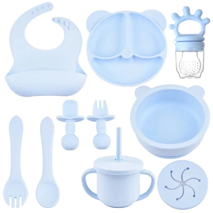 Collection of blue baby feeding and dining utensils including a bib, bowl, cup, and more.