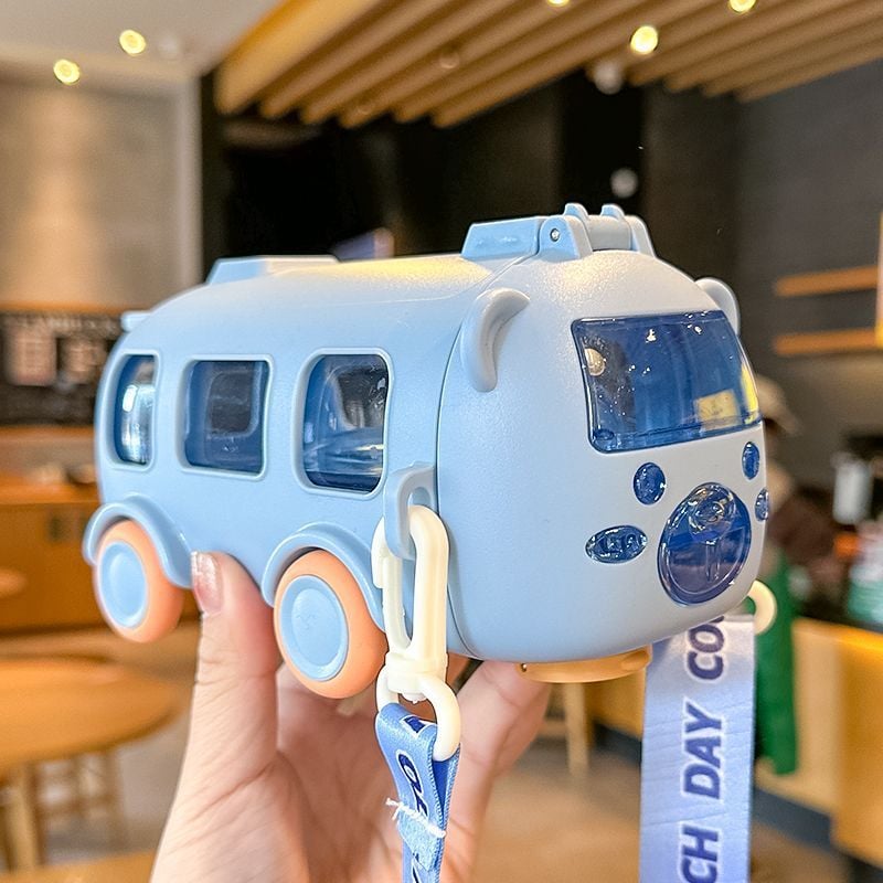 Water bottle & Toy van held by a hand with a blurred indoor background