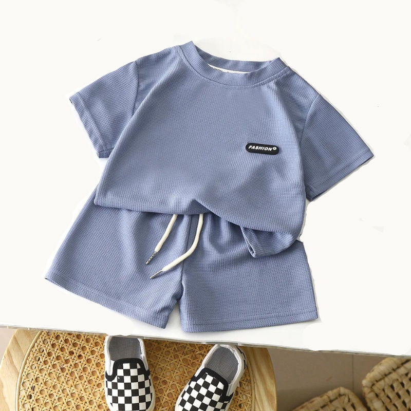 Children's blue outfit with shorts and a checkered shoe on a white background