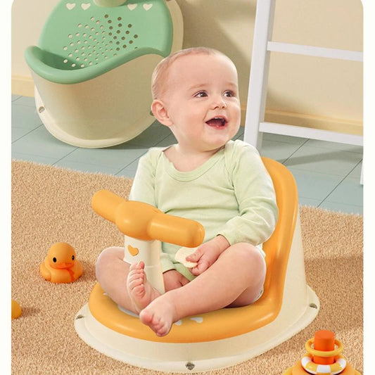 Baby sitting on an orange and white stool with a green and beige chair in the background.