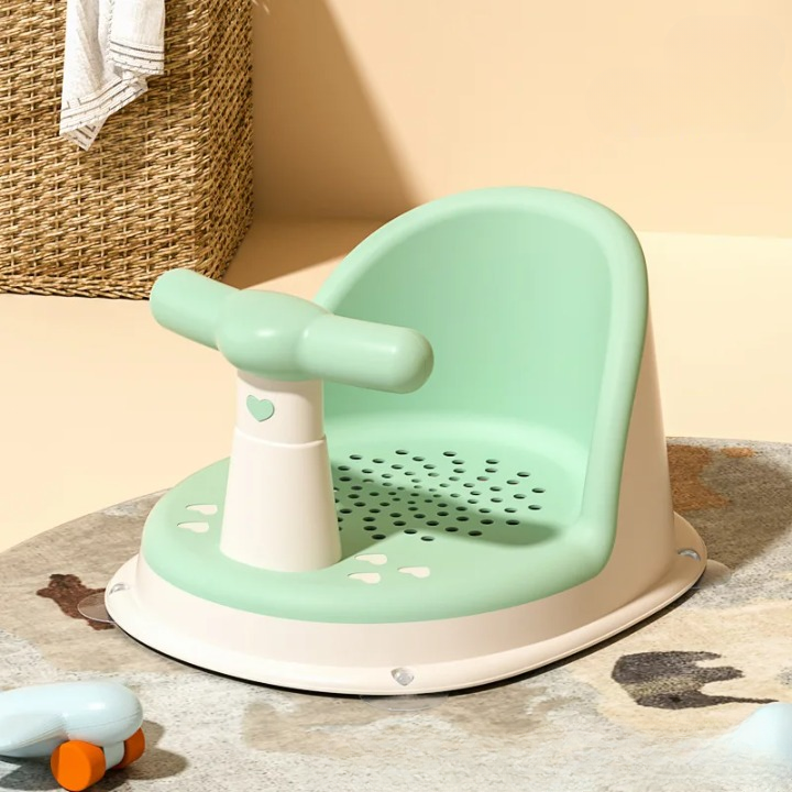 Children's green and beige seat with handle on a beige floor.