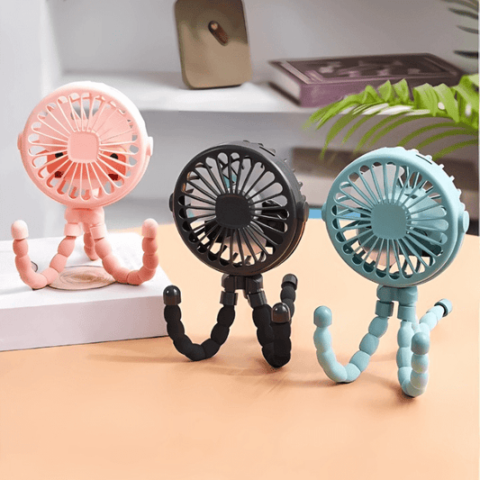 Three portable fans in pink, black, and blue on a light surface with a blurred background.