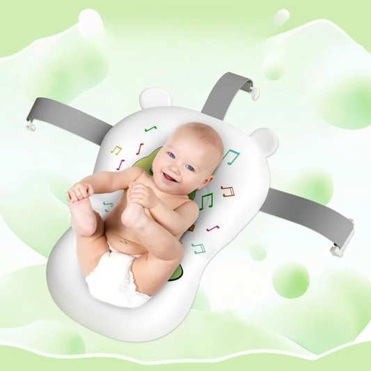 Baby lying on a white bath seat with gray straps against a green background