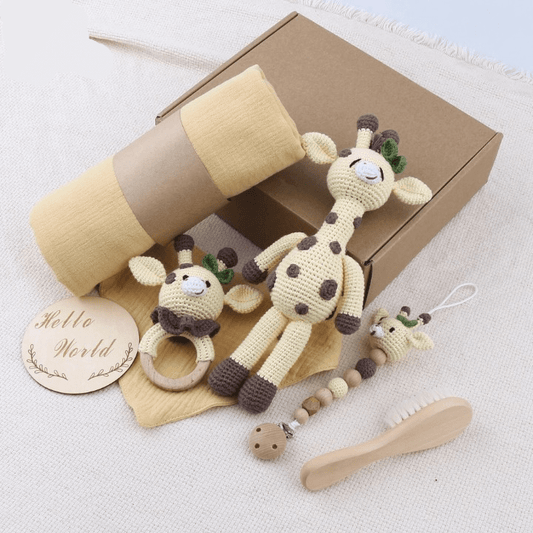 Baby toys and items including a giraffe rattle, brush, and blanket on a light background.