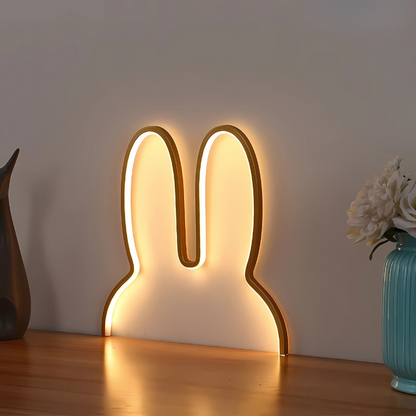 Bunny-shaped LED night light on a wooden surface with a neutral background