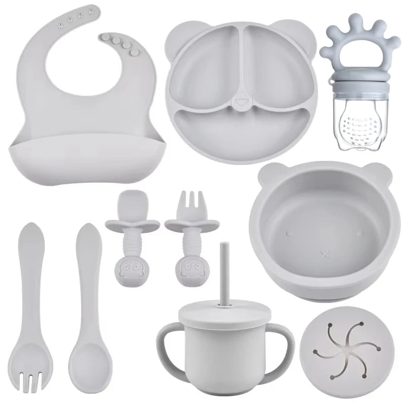Collection of baby feeding utensils and accessories in gray on a white background
