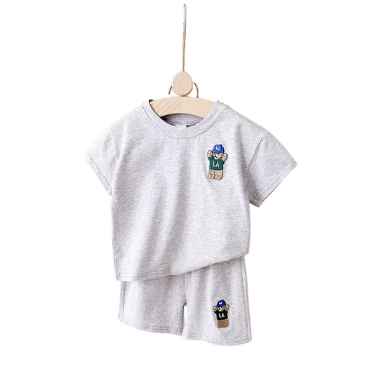 Gray children's t-shirt and shorts set with character patches on a white background