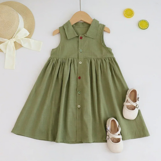Green dress on a hanger with shoes and a hat on a white background