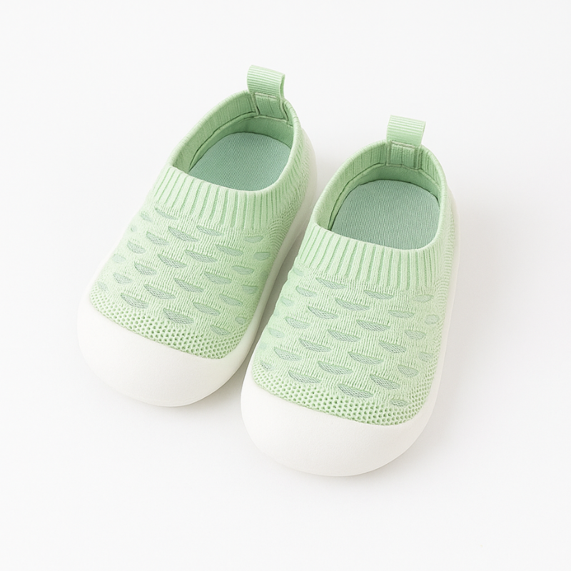 green knit baby shoes on a white background