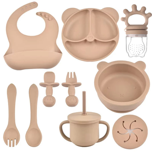 Collection of beige baby feeding utensils and accessories on a white background
