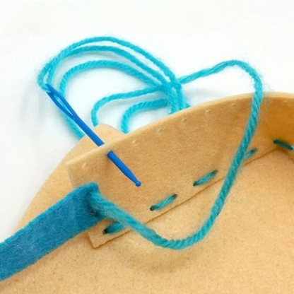 Close-up of blue thread being sewn into a beige fabric.