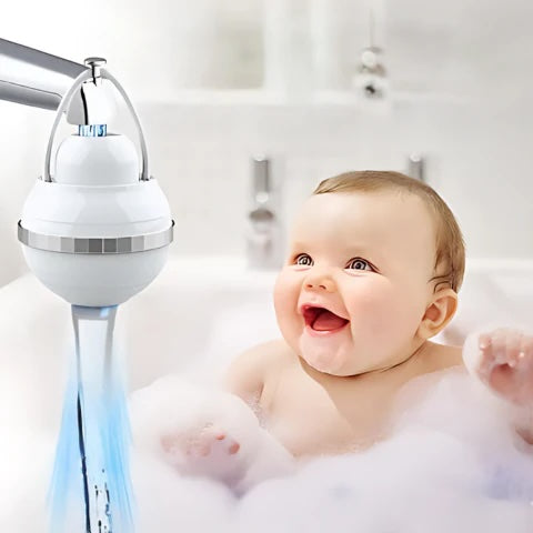 Baby in a bubble bath with a showerhead and water flowing.