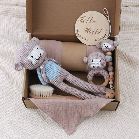Baby toy set with crocheted monkey, brush, and teething ring in a box labeled 'Hello World'.