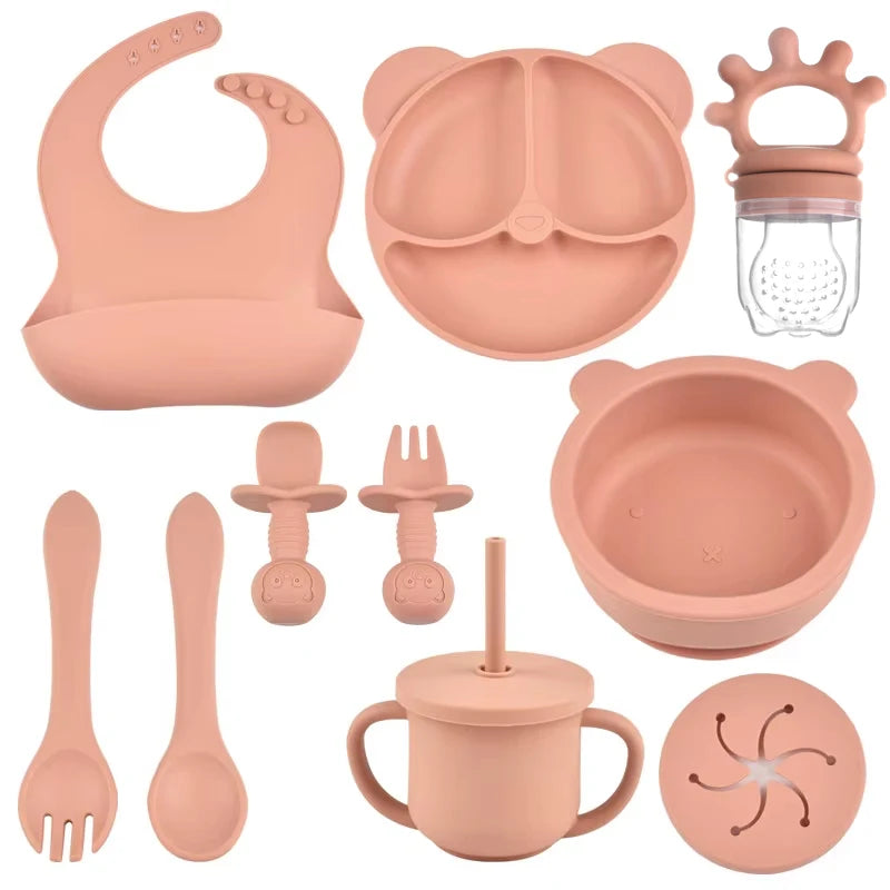 Set of pink baby feeding and teething products on a white background