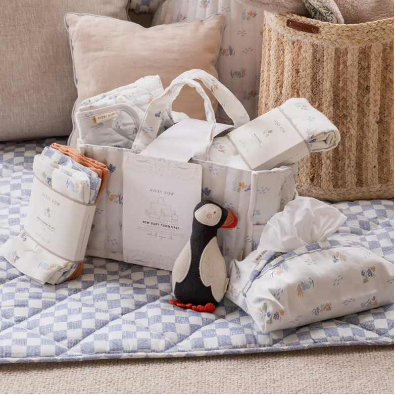 Baby care products including blankets and a plush toy on a checkered blanket.