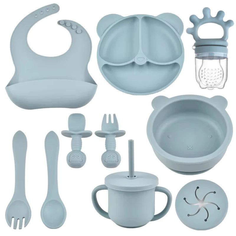 Collection of baby silicone feeding utensils and accessories in a light blue color.