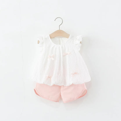 White blouse with ruffled sleeves and Pink shorts on a hanger against a white background