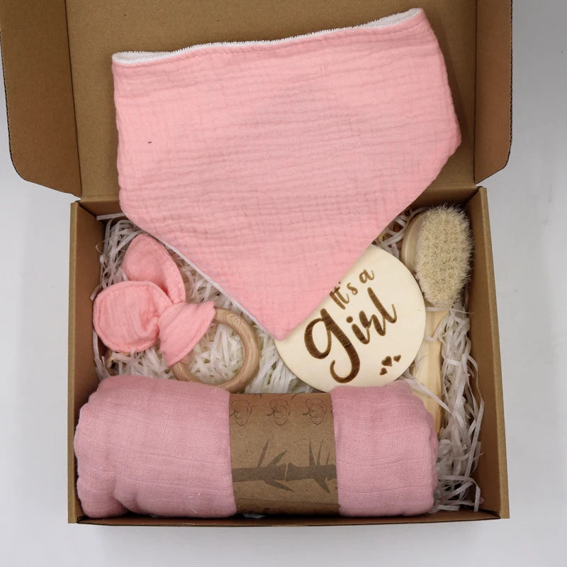 Baby gift set with pink blanket, brush, Teether, and 'it's a girl!' card in a box.