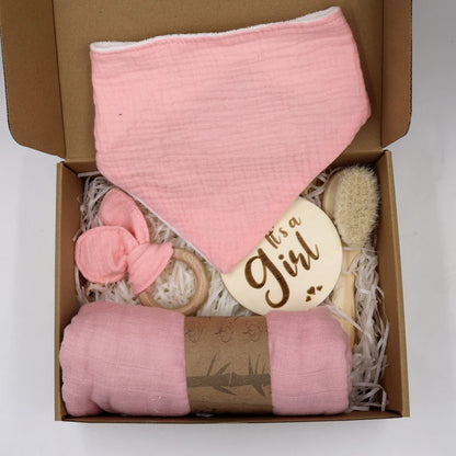 Baby gift set with pink blanket, brush, Teether, and 'it's a girl!' card in a box.