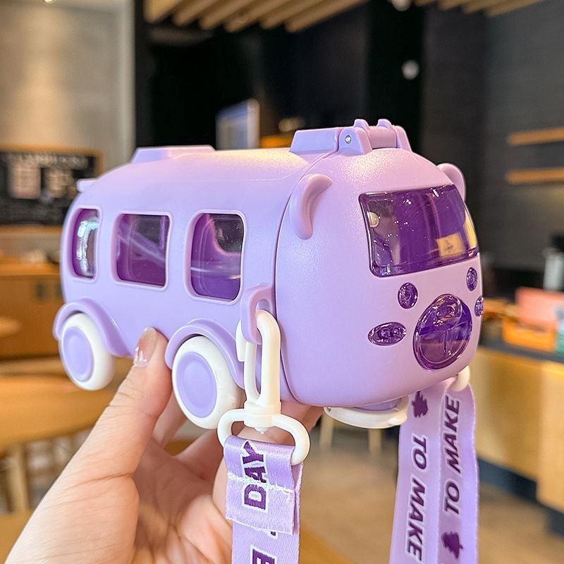 Purple water bottle & toy bus with a lanyard held by a hand in an indoor setting