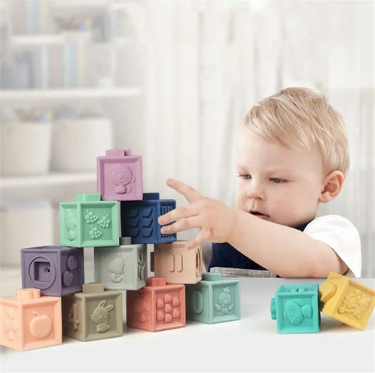 Child playing with colorful silicone blocks on a white surface