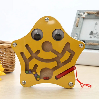 Star shaped maze toy on a light surface with a blurred background