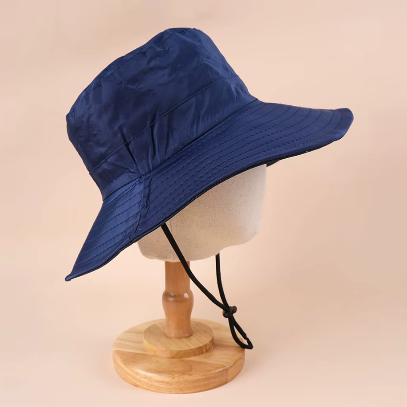 Navy bucket hat on a mannequin head against a beige background