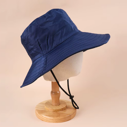 Navy bucket hat on a mannequin head against a beige background