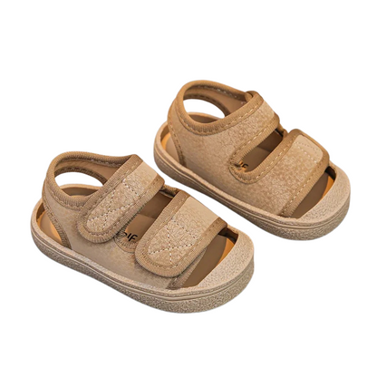 Pair of beige sandals with velcro straps on a white background