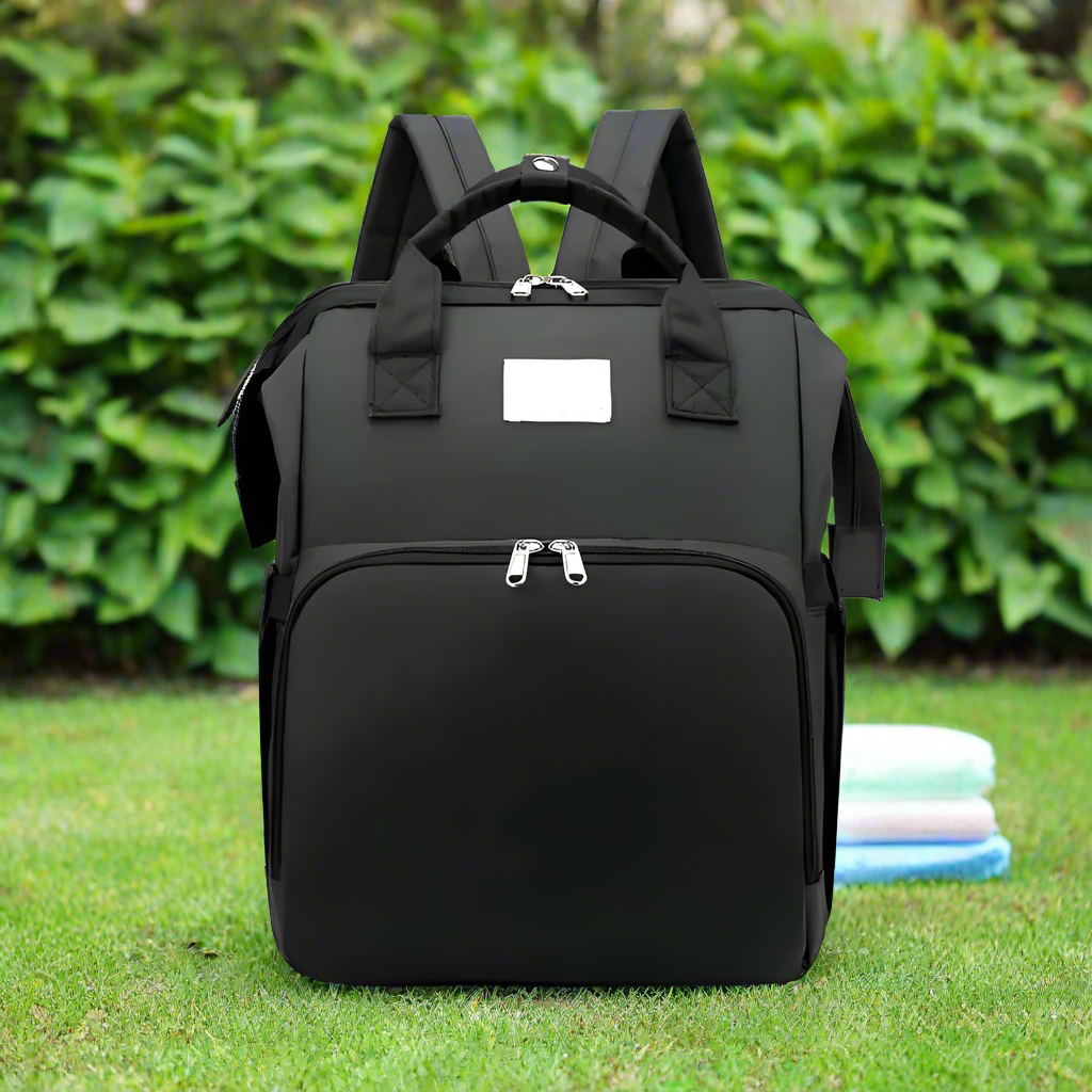Trekaroo baby backpack in sleek black, standing upright with zipper compartments visible.