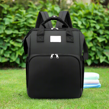 Trekaroo baby backpack in sleek black, standing upright with zipper compartments visible.