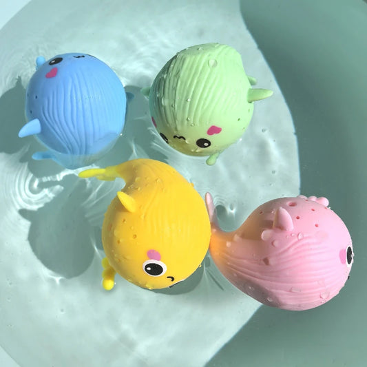 Four colorful rubber duck toys in a bathtub