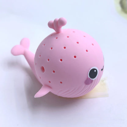 Pink whale-shaped tea infuser on a white background