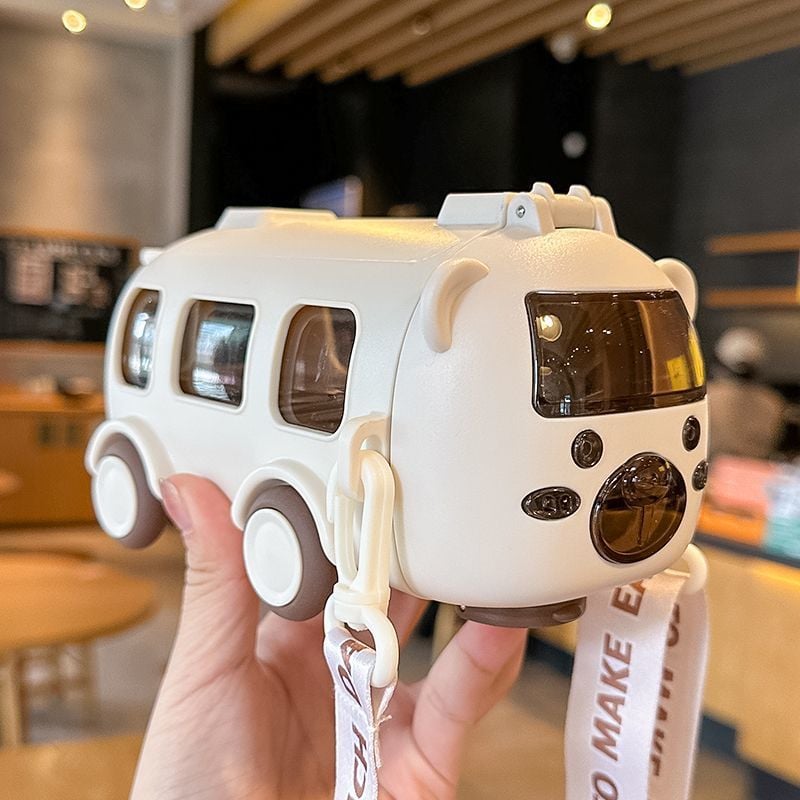 water bottle & Toy bus with a lanyard held by a hand in an indoor setting