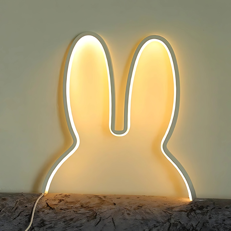 Neon light shaped like a rabbit on a wooden surface with a neutral background