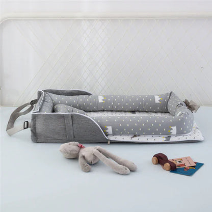 Gray baby crib with star pattern and toys on a white surface