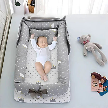 Baby lying in a gray and white patterned crib with toys around