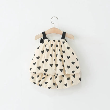 Baby top and shorts with black heart pattern on a white background
